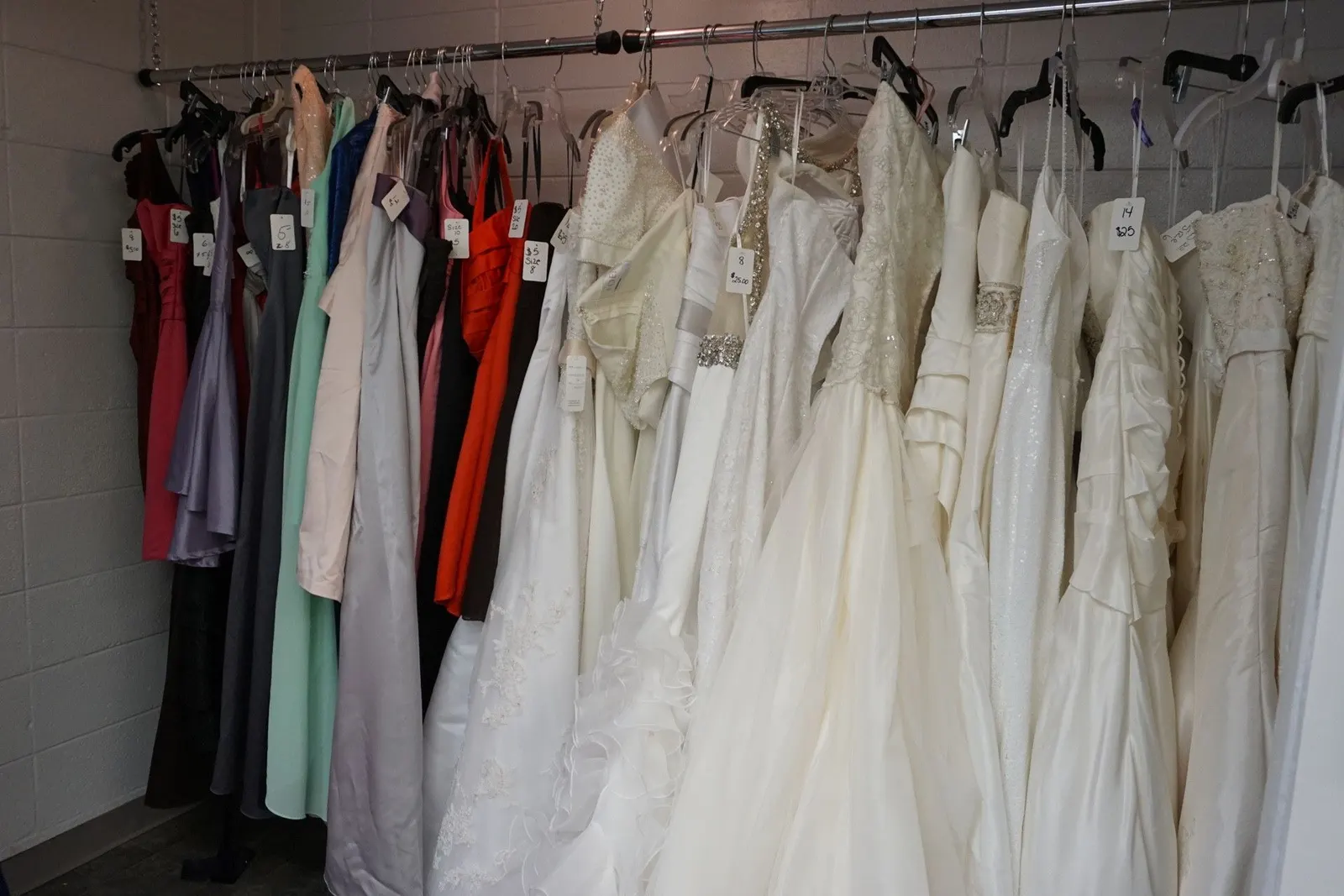 Wedding dresses and formal gowns on racks in the Thrift Store